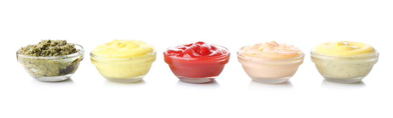 Different tasty sauces in glass bowls on white background