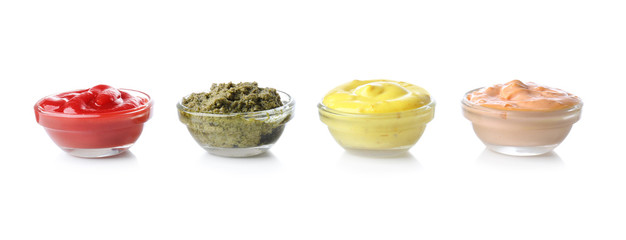Different tasty sauces in glass bowls on white background