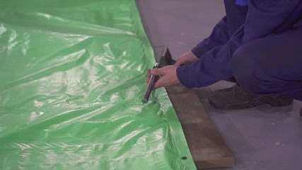 preparation of the eyelet on the plastic tent