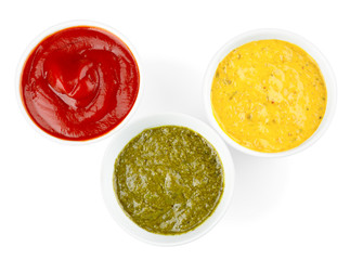 Different tasty sauces in bowls on white background