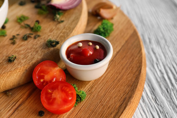 Tasty tomato sauce in bowl on wooden board