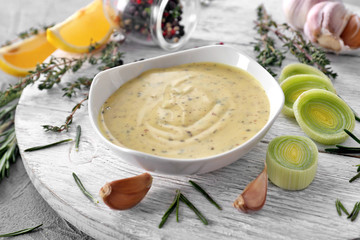 Tasty sauce in bowl on white wooden board