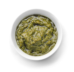 Tasty basil sauce in bowl on white background