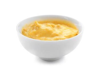 Tasty yellow sauce in bowl on white background