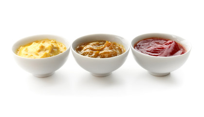 Different tasty sauces in bowls on white background