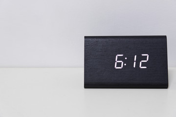Black digital clock on a white background showing time 6:12