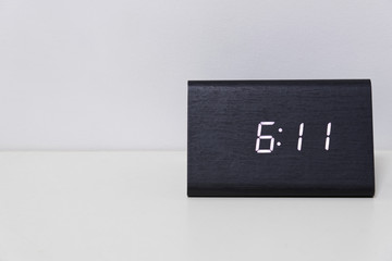 Black digital clock on a white background showing time 6:11