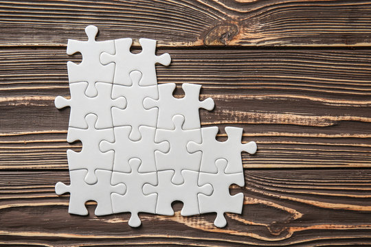 Incomplete jigsaw puzzle on wooden background Stock Photo | Adobe Stock