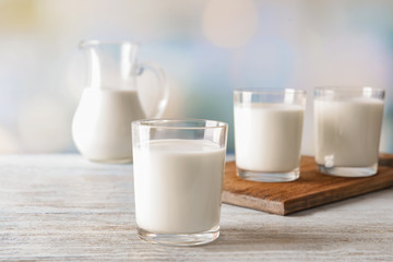 Glasses of fresh milk on wooden table
