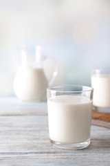 Glass of tasty milk on wooden table