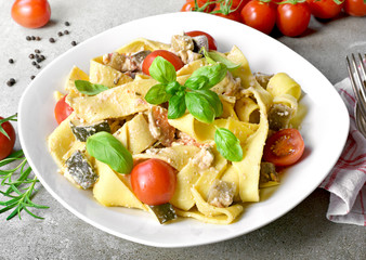 Delicious pasta dish with ricotta sauce and fresh herbs. Tagliatelle noodles on a white plate, italian cuisine. Top view or high angle shot.