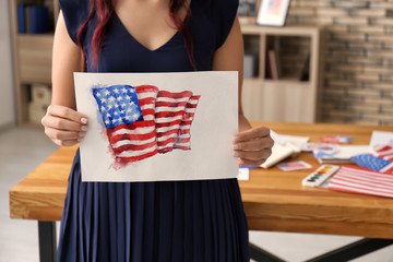Woman holding watercolor painting of American national flag, closeup