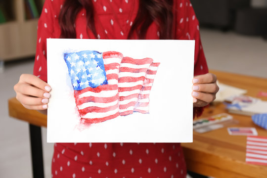Woman holding watercolor painting of American national flag, closeup
