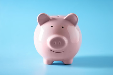 Ceramic piggy bank on color background