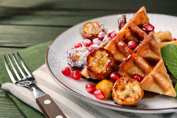 Sweet fresh waffles with fruits on plate, closeup