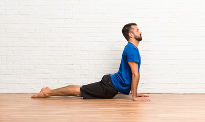 Fototapeta premium Man doing yoga exercises indoors
