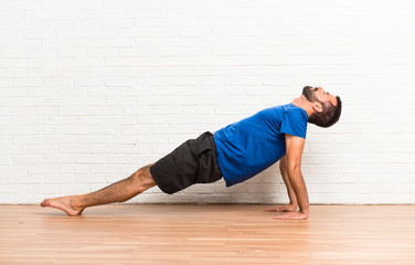 Fototapeta na wymiar Man doing yoga exercises indoors