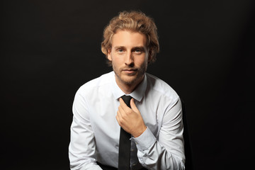 Portrait of young businessman on black background