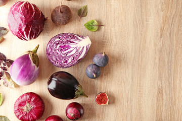 Various fresh vegetables with figs on wooden table