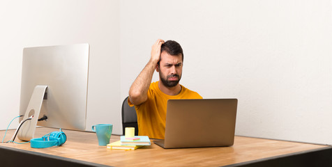 Man working with laptot in a office with an expression of frustration and not understanding