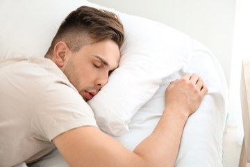 Obraz na płótnie Canvas Handsome man sleeping in bed at home