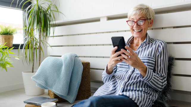 Smiling beautiful senior woman using digital tablet at home