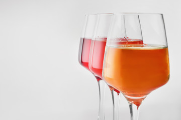 Glasses of tasty wine on white background