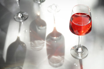 Glass of tasty wine on light table