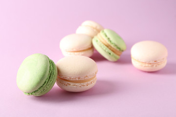 Fresh tasty macaroons on color background