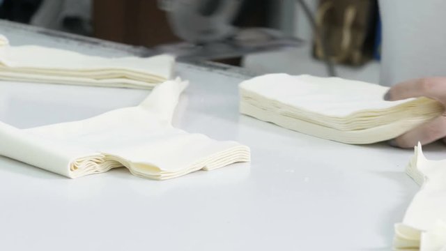 Cutting the fabric, sewing work. Cutting room, cutting light beige cloth tailoring knife.