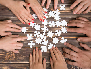 Group of people doing puzzle on table