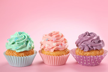 Tasty cupcakes on color background