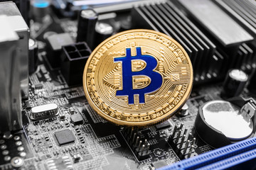 Golden bitcoin on PC circuit board