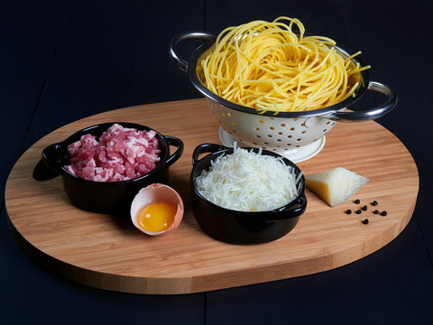 Ingredients for spaghetti carbonara: fresh spaghetti, grated pecorino romano, bacon (or guanciale), egg yolk, black peppercorns