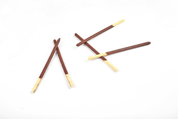 Biscuit sticks in chocolate coating on white background.