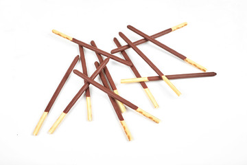 Biscuit sticks in chocolate coating on white background.