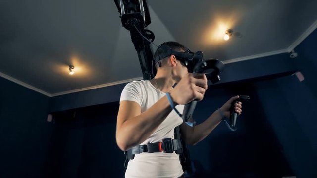 Virtual reality gaming concept. Young man in the middle of gaming process with a virtual reality system