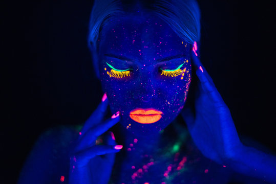 Portrait of Beautiful Fashion Woman in Neon UF Light. Model Girl with Fluorescent Creative Psychedelic MakeUp, Art Design of Female Disco Dancer Model in UV, Colorful Abstract Make-Up