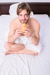 Fresh bakery product. Man bearded handsome guy eating breakfast in bed. French breakfast...
