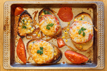 Casseroles and mini pizza - tasty snacks with tomato and cheese with green piet. Tray after baking.