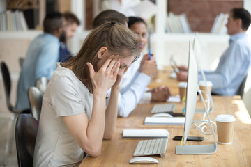 Sick woman distracted from work feeling unwell sitting in front of computer, stressed female employee have anxiety attack at workplace, upset woman suffer from headache or dizziness in office