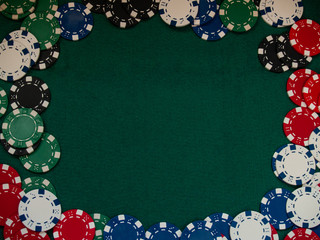 Poker chips of various colors on a green mat