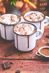 Hot chocolate with marshmallow candies on wooden background.