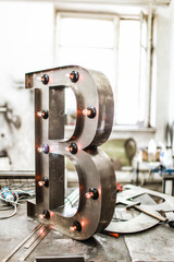 metal letter B with led light bulbs isolated on interesting background