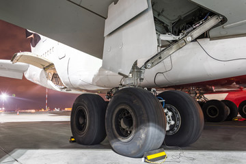 Wheels rubber tire rear landing gear racks airplane aircraft, under wing view night.