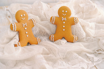 gingerbread men on abstract light background. traditional tasty cookies for festive winter season. cozy cute symbol of Christmas holiday. template for design. copy space