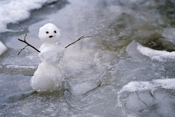 melted snow and snowman in puddle, natural abstract background. bad rainy winter weather, anomaly...