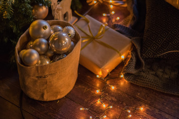 winter decor: Christmas tree, gifts in craft paper, wooden DIY deer, garland, golden and white balls. Selected focus