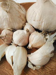 High angle view and close up of white  garlic cloves and bulb on wooden plate. Spicy and pungent. Seasonings for dishes in Taiwanese cuisine. Natural agricultural product and vegetable.