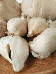 High angle view and close up of white  garlic cloves and bulb on wooden plate. Spicy and pungent. Seasonings for dishes in Taiwanese cuisine. Natural agricultural product and vegetable.